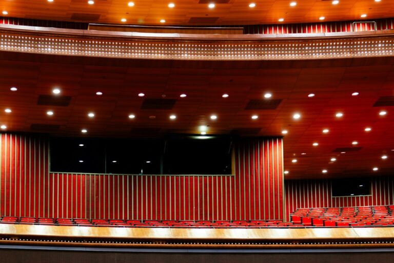 Empty red seats and a stage in a large church auditorium