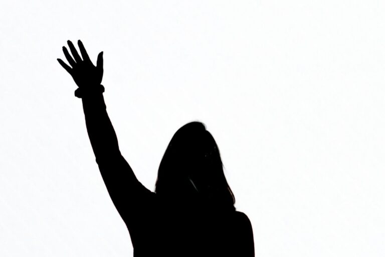 A silhouette of a person with one hand raised