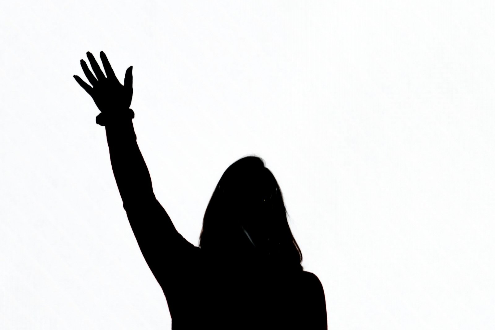 A silhouette of a person with one hand raised