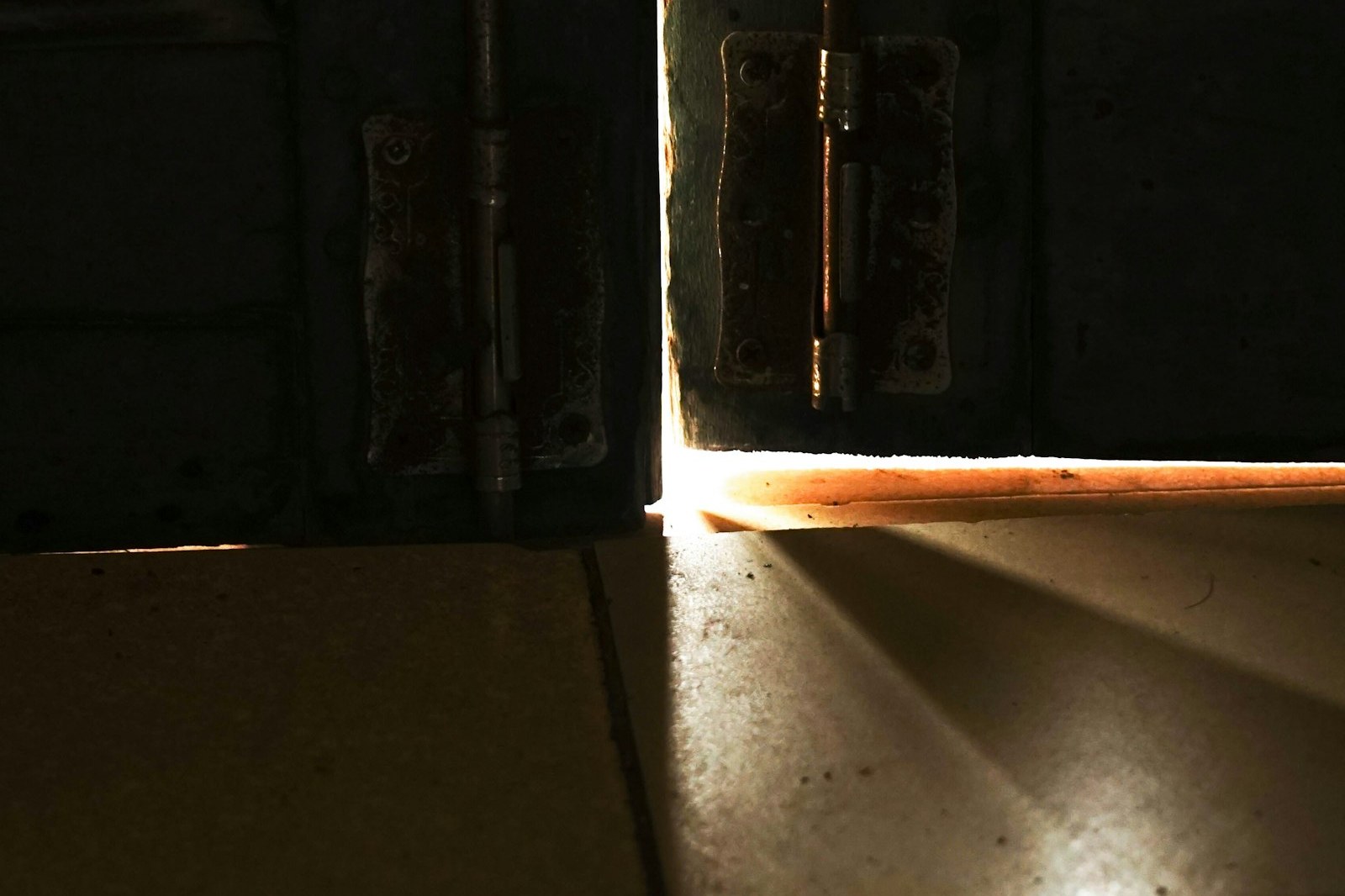 A door open to a sliver of warm light