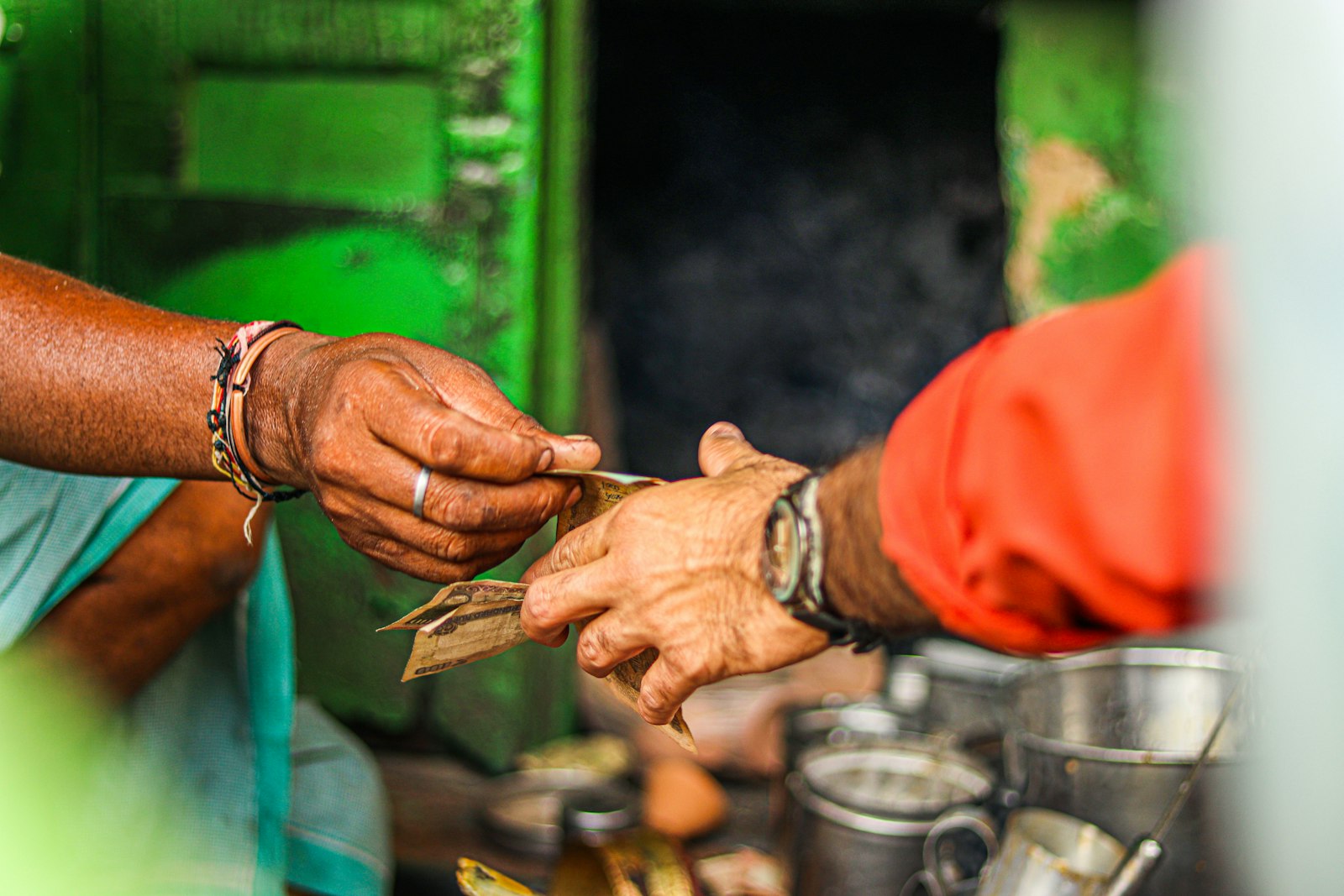 One person handing money directly into another person's hand