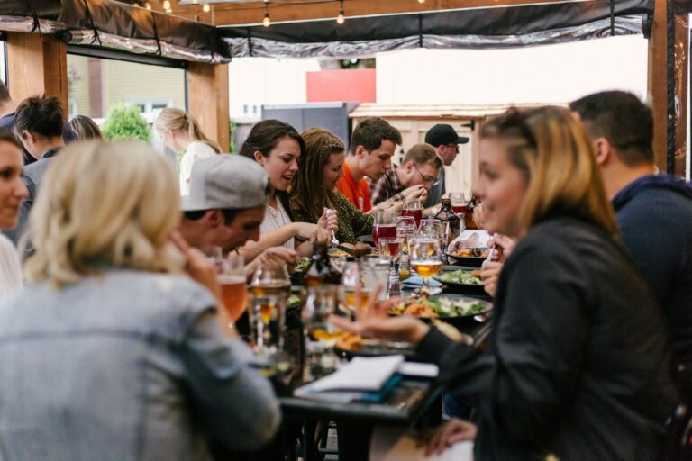 People gathered around a long table sharing a meal and conversation